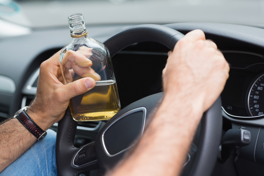 Photo of a Man Drinking Alcohol While Driving