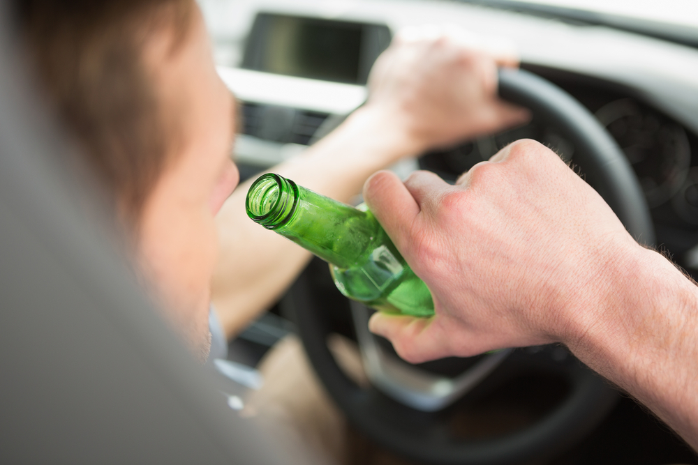Photo of a Man Drinking While Driving