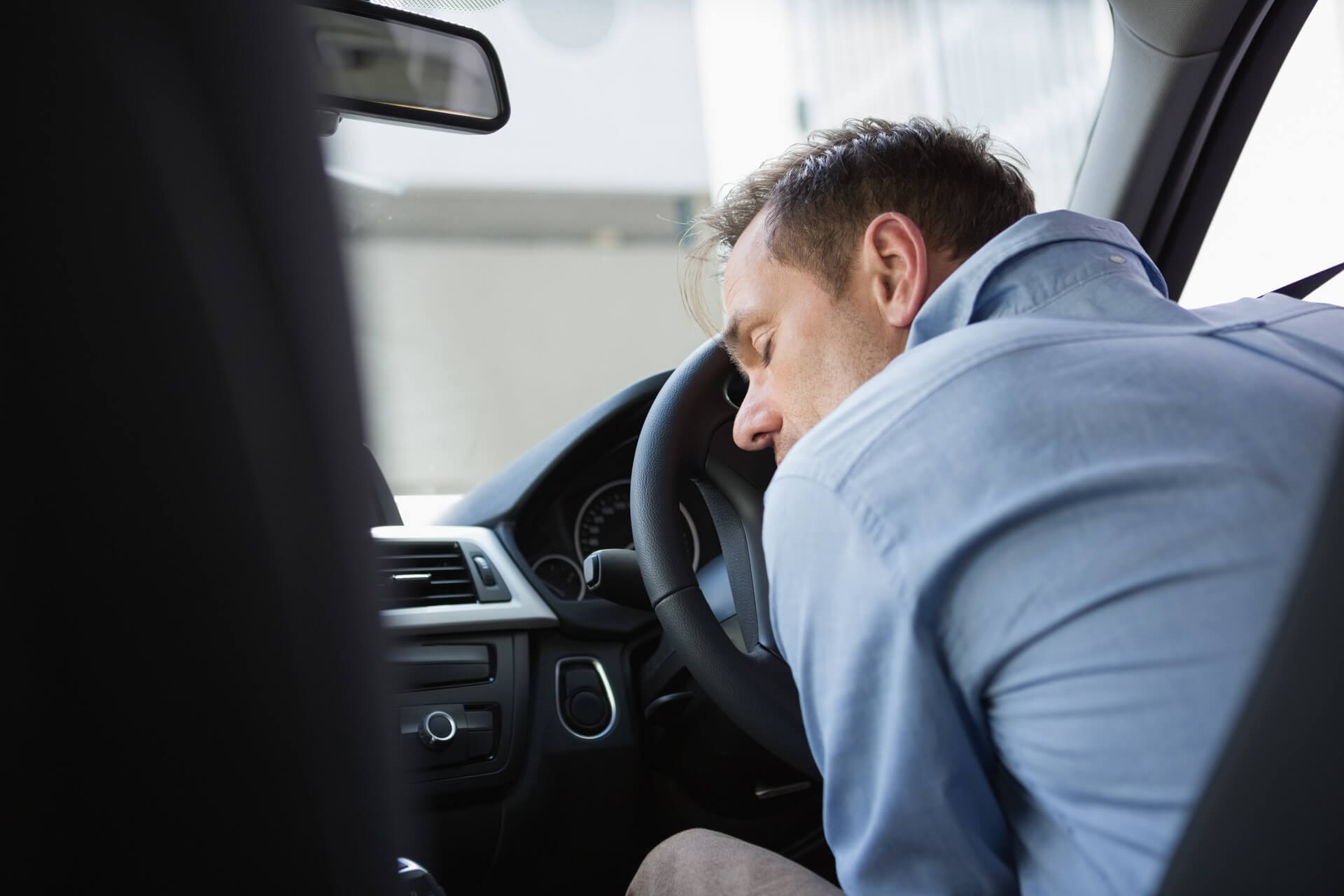 man sleeping inside a car